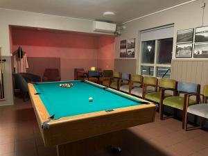 a billiard room with a pool table and chairs at Bjarg at Lyngholt in Þórshöfn