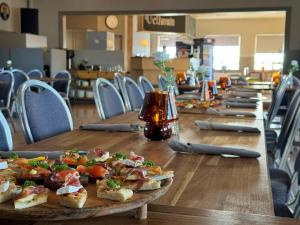 a row of wooden tables with plates of food on them at Bjarg at Lyngholt in Þórshöfn