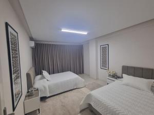 a hotel room with two beds and a window at Chez-moi in Sfax