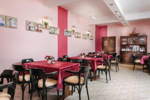 a dining room with red tables and chairs at Vila Sentandreja in Subotica