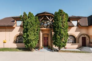 a house with trees in front of it at Vila Sentandreja in Subotica