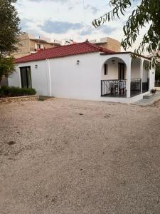 a white building with a red roof at Luciano Rooms in Ksamil