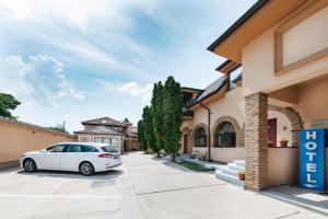 a white car parked in front of a house at Vila Sentandreja in Subotica