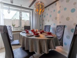 a dining room with a table with cups and dishes on it at Ferienhaus in Tönning in Tönning +69 photos