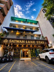 a white car parked in front of a building at Hotel Satwah Luxe Stay - 1 Minute From Nizamuddin Railway Station And India Gate in New Delhi