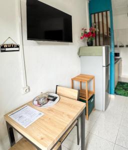 a kitchen with a wooden table and a refrigerator at L'échappée verte in Chirongui
