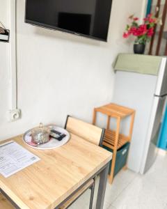 a table and chair with a television on the wall at L'échappée verte in Chirongui +4 photos