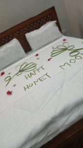 a bed with a white blanket with flowers on it at Googles Beach Hotel Zanzibar in Zanzibar City