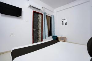 a white bedroom with a bed and a window at Hotel O City Star in Rewa +26 photos