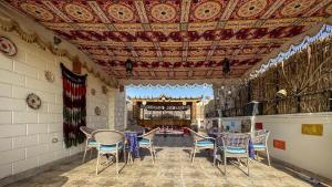 a patio with chairs and tables and a ceiling at Atlantis Pyramids Inn in Giza