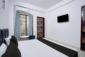 a bedroom with a bed and a tv on the wall at Hotel O City Star in Rewa