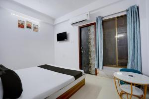 a bedroom with a bed and a table and a window at Hotel O City Star in Rewa