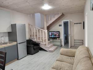 a living room with a couch and a staircase at Уютная Дача in Zatoka
