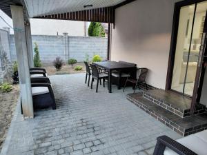 a patio with a black table and chairs at Уютная Дача in Zatoka +5 photos