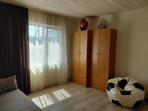 a living room with a bed and a large window at Уютная Дача in Zatoka