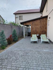 two chairs sitting on a patio next to a building at Уютная Дача in Zatoka