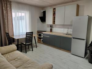 a kitchen with a couch and a table and a refrigerator at Уютная Дача in Zatoka
