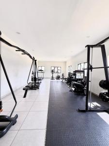 a gym with several treadmills and exercise machines at Studio Luxe The Aura Your Calm Escape in Northriding