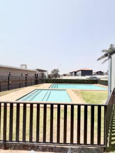 an empty swimming pool with a fence around it at Studio Luxe The Aura Your Calm Escape in Northriding