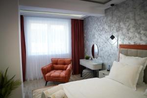 a bedroom with a bed and a chair and a sink at Stay Unique in Râşnov