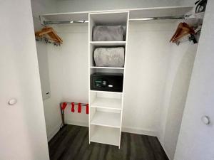 a walk in closet with white walls and shelves at 30th Fl Beachwalk Studio Bay Balcony in Hallandale Beach