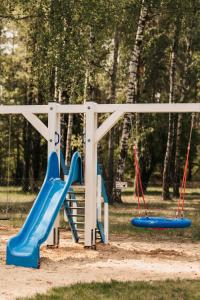 a playground with two swings and a slide at Apart & Plus 1 in Okuninka