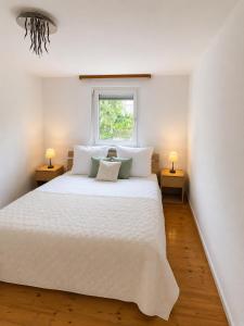 a bedroom with a large white bed with two lamps at Danube Lodge in Hüfingen