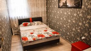a bedroom with a bed with red flowers on it at Vidiecky dom Leles in Leles