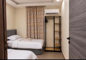 a small room with two beds and a closet at Pyramids Gardens 2bedroom apartment in ‘Ezbet `Abd el-Ḥamîd