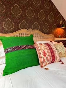 a green pillow sitting on top of a bed at The White Rabbit Rooms in Broadford
