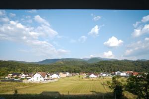 a village with a field and mountains in the background at Stay Unique in Râşnov