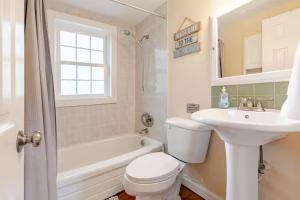 a white bathroom with a sink and a toilet at Dennis Beach House - Walk to Beach - Pet Friendly in Dennis +14 photos