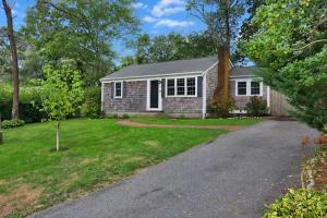 a small brick house with a driveway at Dennis Beach House - Walk to Beach - Pet Friendly in Dennis