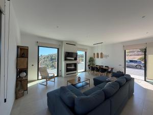 a living room with a blue couch and a table at Vivienda en Granada, Cortijo Balcón Cotobro, Almuñécar, Casa con piscina y vistas increíbles in Granada