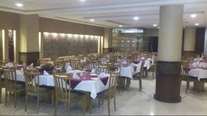 a dining room with white tables and chairs at New Panoramic Hotel in Lahore