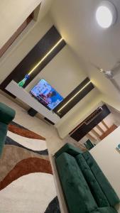 a living room with a flat screen tv on the ceiling at Gods Grace homes in Duasi