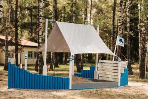 a tent on a playground with a bench at Apart & Plus in Okuninka