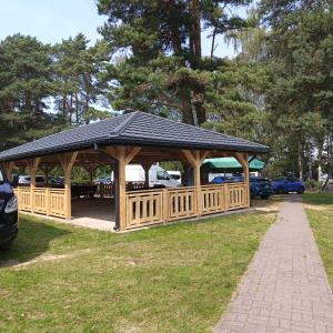 a wooden gazebo with a black roof at Apart & Plus 2 in Okuninka +6 photos