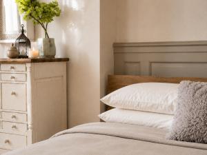 a bedroom with a bed and a dresser with a pillow at Fontaine Studio Appartement in Ribérac