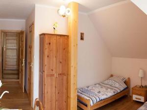 a bedroom with a bed and a wooden cabinet at 4-person room, sauna, Masuria in Ruciane-Nida