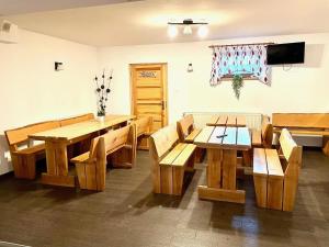 a room with wooden tables and benches and a television at 4-person room, sauna, Masuria in Ruciane-Nida