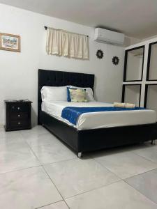 a bedroom with a large bed with a black headboard at Mi Casa18 in Santa Marta