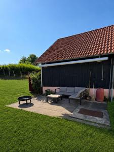 a patio with a couch and a table in a yard at Danube Lodge in Hüfingen
