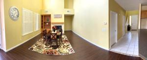 a hallway with a table and a clock on the wall at la paz room 1 in Fresno