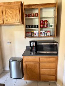 a kitchen with a microwave and a trash can at la paz room 1 in Fresno
