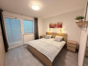 a bedroom with a bed and a large window at Pannonian Nest - app Rebolj in Moravske-Toplice