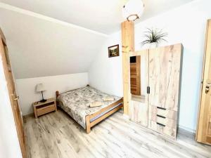 a small bedroom with a bed and a cabinet at Double room, sauna, Masuria in Ruciane-Nida
