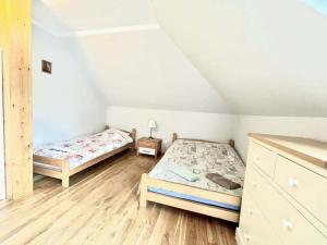 a bedroom with two beds in a attic at Triple room, sauna, Masuria in Ruciane-Nida