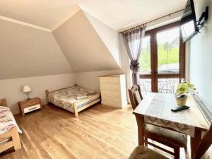 a bedroom with a bed and a desk and a window at Triple room, sauna, Masuria in Ruciane-Nida