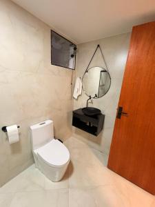 a bathroom with a white toilet and a mirror at Hospedaria Santa Inês in Cachoeira Paulista +11 photos